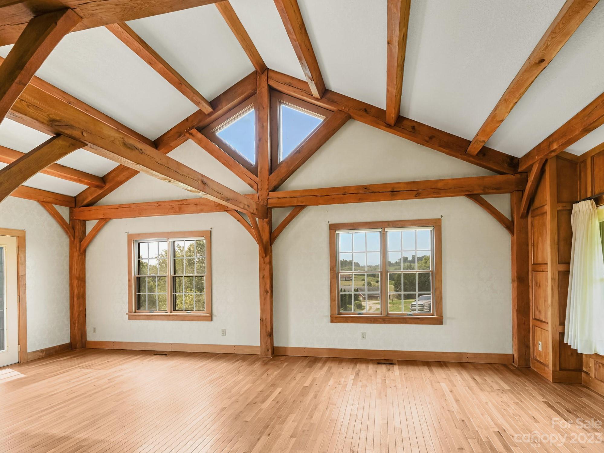 386 Heather Downs Drive Alexander, NC 28701 - Photo 13 of 29 an empty room with wooden floor and windows