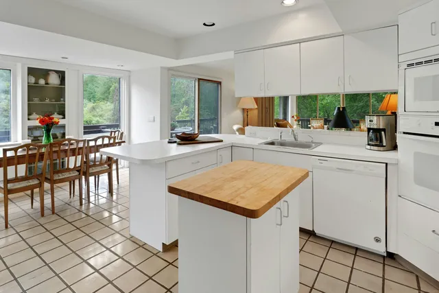 a kitchen with stainless steel appliances granite countertop a sink and a refrigerator