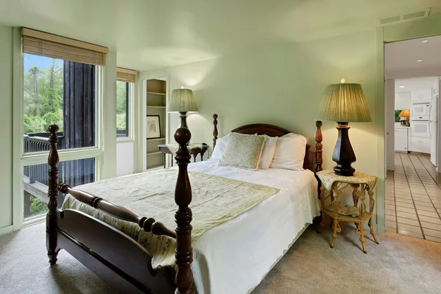 a bed sitting in a bedroom next to a window