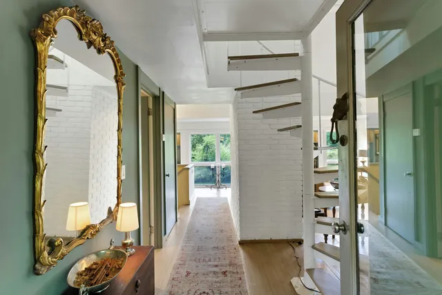 a view of a hallway to a livingroom with furniture