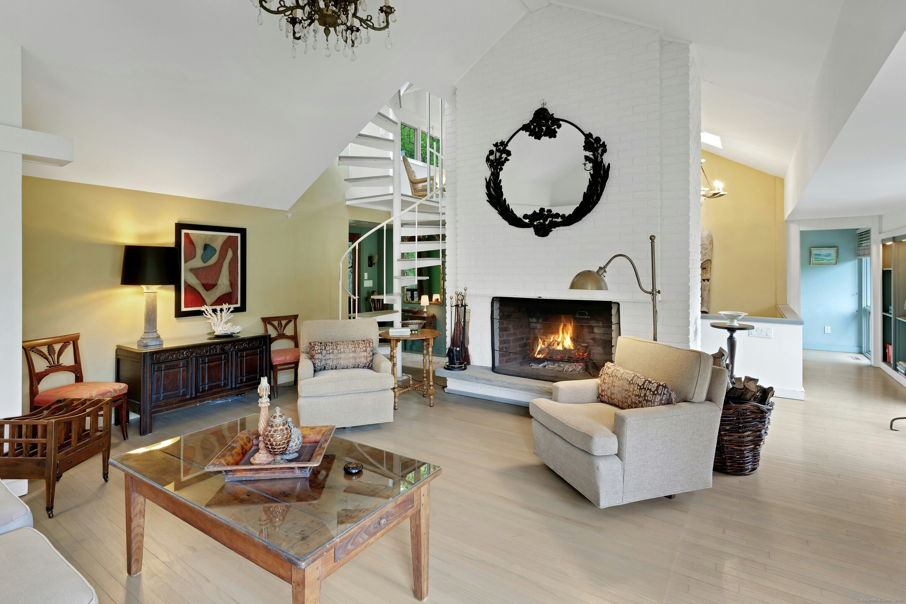 32 Beeholm Road Redding, CT 06896 - Photo 6 of 40 a living room with couches a fireplace and a large mirror with wooden floor
