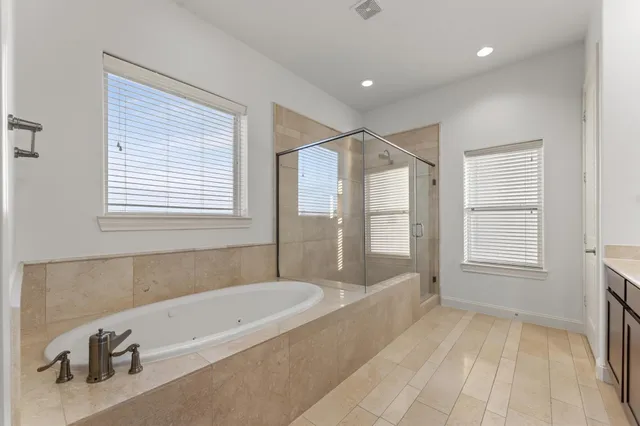 a spacious bathroom with a tub a sink and a mirror