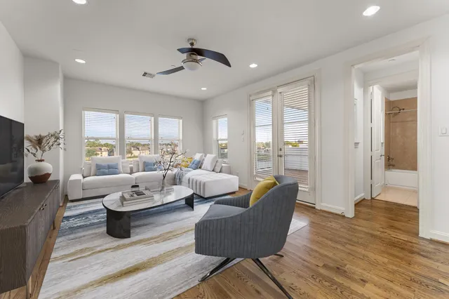 a living room with furniture wooden floor and a large window