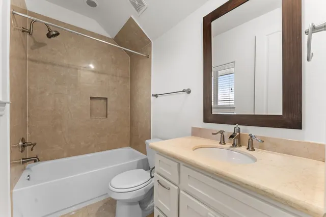 a bathroom with a granite countertop sink a toilet and shower