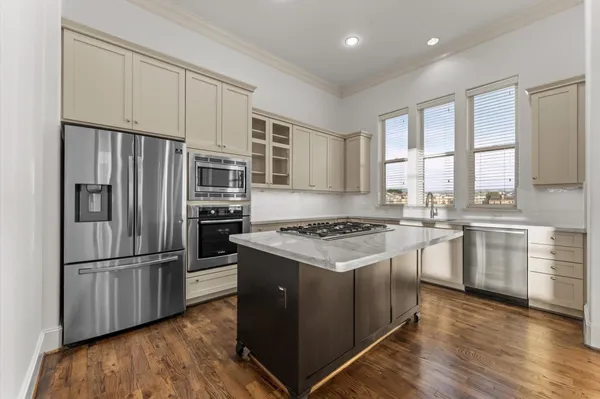 a kitchen with a refrigerator stove and wooden cabinets