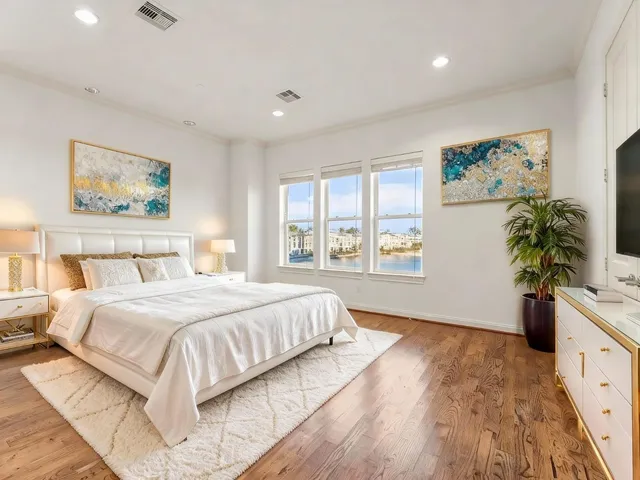 a bedroom with a large bed and a potted plant
