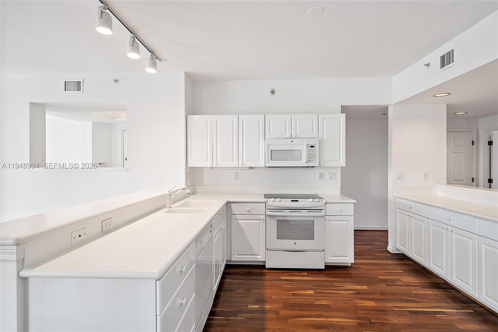 1660 Florida A1A, Unit 222 Jupiter, FL 33477 - Photo 6 of 34 a kitchen with a stove top oven sink and cabinets