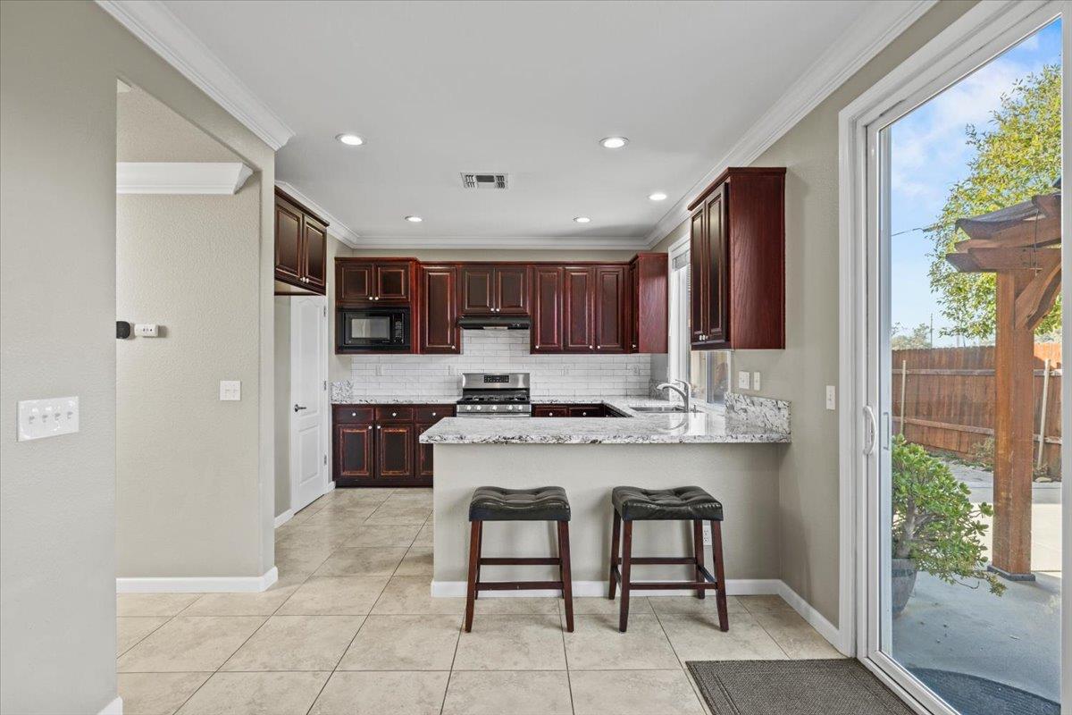 4056 Aitken Dairy Road Rocklin, CA 95677 - Photo 26 of 59 a kitchen with a sink a refrigerator and chairs