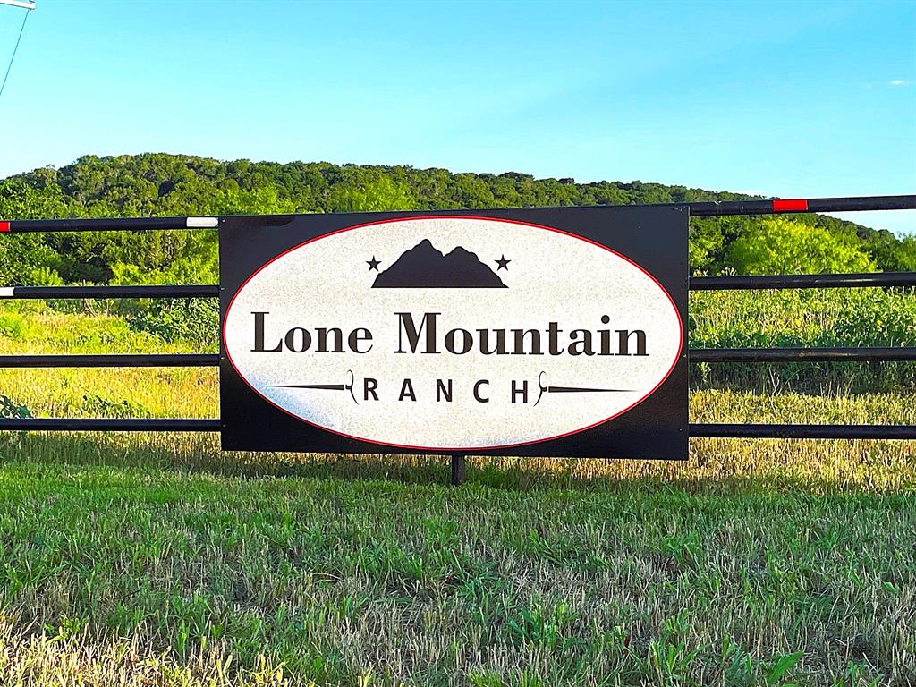 200 Pr 16028 Road Jonesboro, TX 76538 - Photo 1 of 17 Property entrance featuring a black metal gate with a decorative Lone Mountain Ranch sign