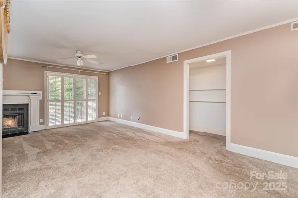 a view of an empty room with a fireplace and a window