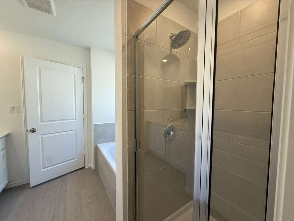 577 Sormonne Loop Kyle, TX 78640 - Photo 25 of 39 a bathroom with a shower and a glass door