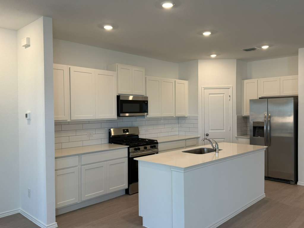 577 Sormonne Loop Kyle, TX 78640 - Photo 7 of 39 a kitchen that has a sink and a stove in it