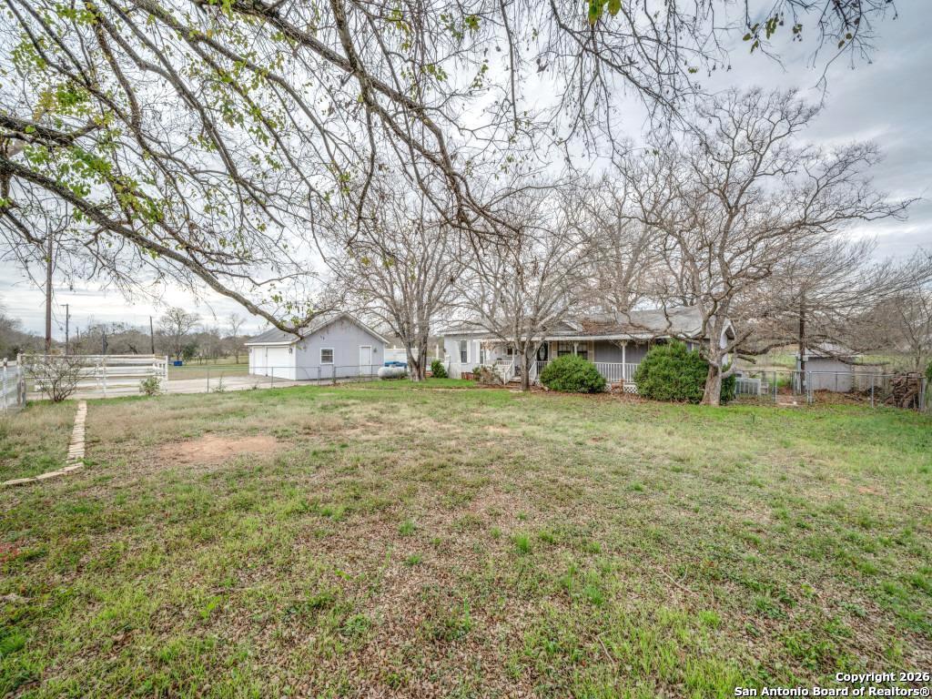 7431-7433 Real Road China Grove, TX 78263 - Photo 14 of 17 a view of a patio with a table and chairs under a large tree