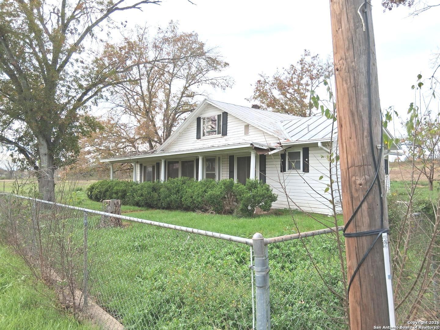 7431-7433 Real Road China Grove, TX 78263 - Photo 6 of 17 a front view of a house with a yard and potted plants