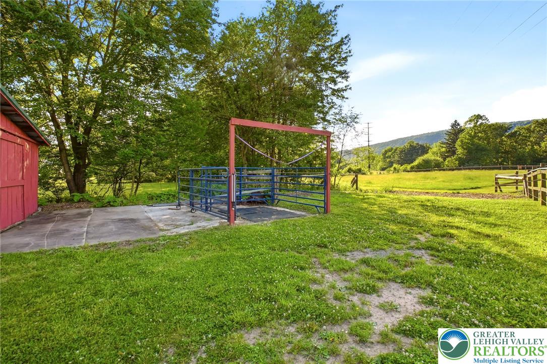 9033 Loop Road Slatington, PA 18080 - Photo 48 of 53 A spacious green pasture awaits, framed by wooded hills and a clear blue sky.