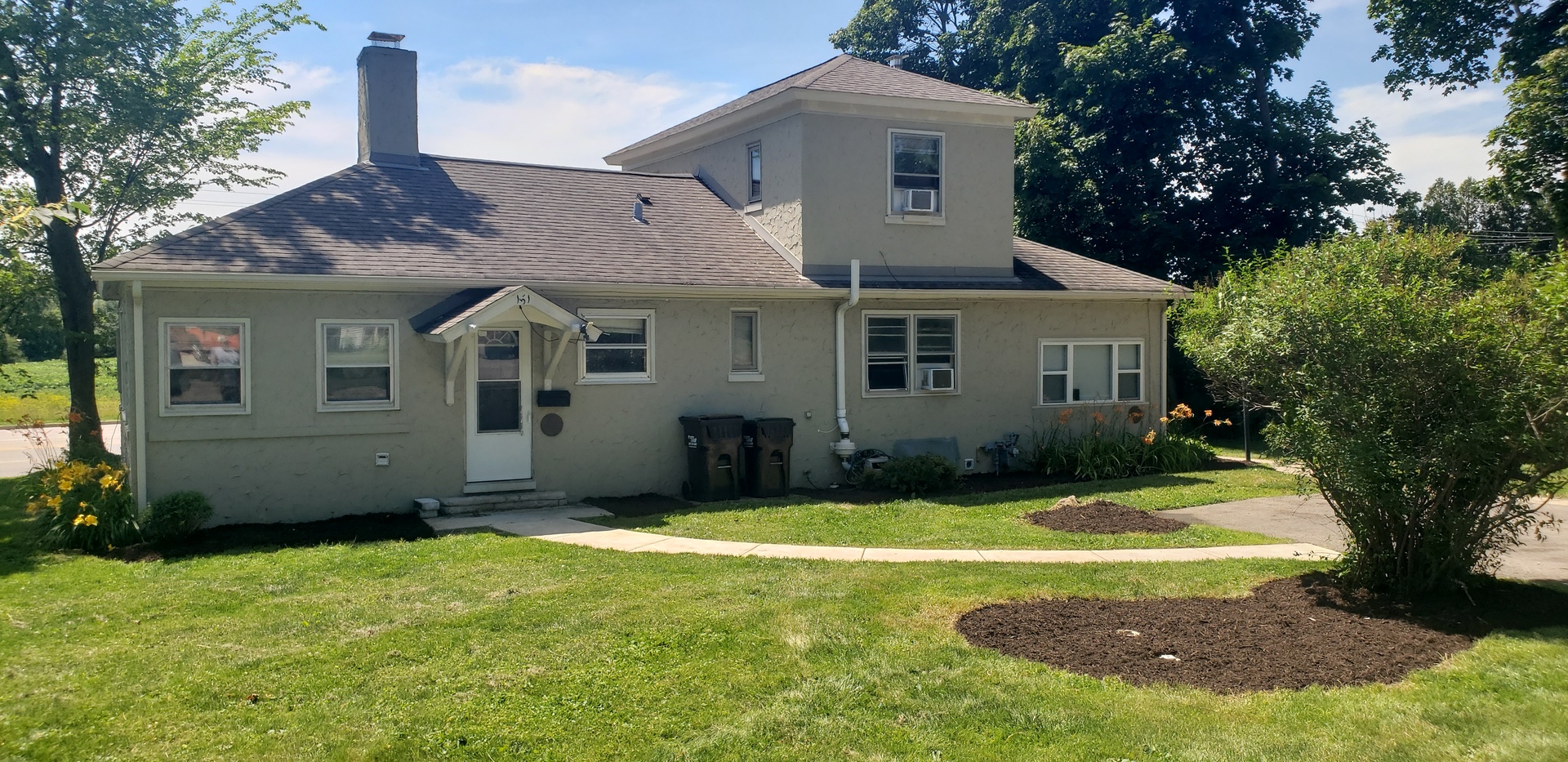 a front view of a house with yard and green space