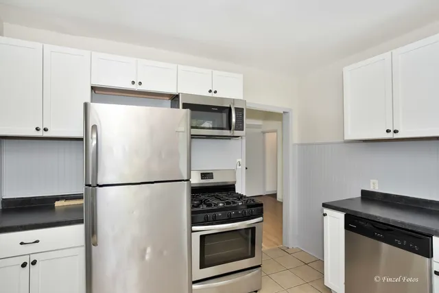 a kitchen with stainless steel appliances a refrigerator stove and microwave
