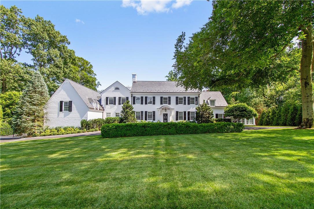 a view of a house with a big yard and large trees