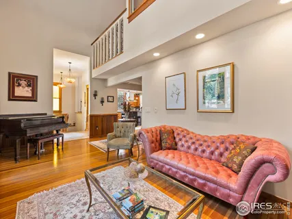 a living room with furniture a couch and paintings on the wall