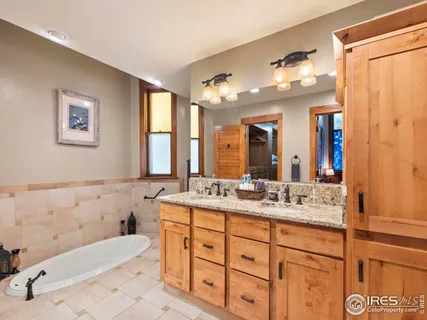 a bathroom with a granite countertop sink mirror vanity bathtub and a toilet