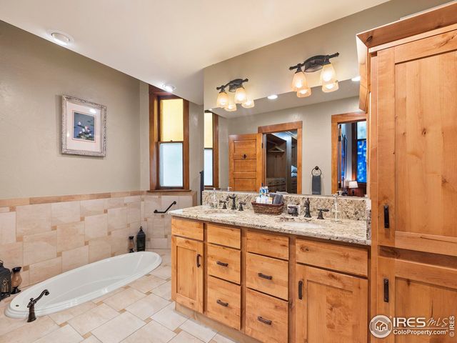 a bathroom with a granite countertop sink mirror vanity bathtub and a toilet