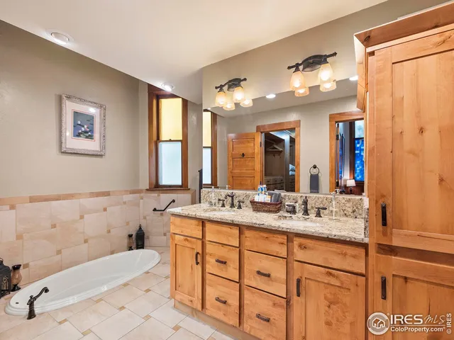 a bathroom with a granite countertop sink mirror vanity bathtub and a toilet