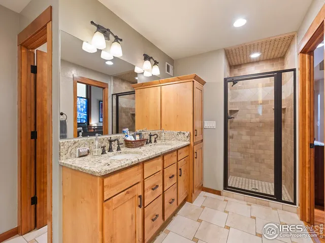 a bathroom with a shower sink vanity and mirror