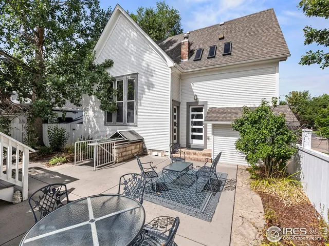 a view of a patio with table and chairs with wooden fence and plants