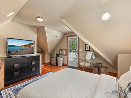 a bedroom with a bed two lamps and a large window with outer view