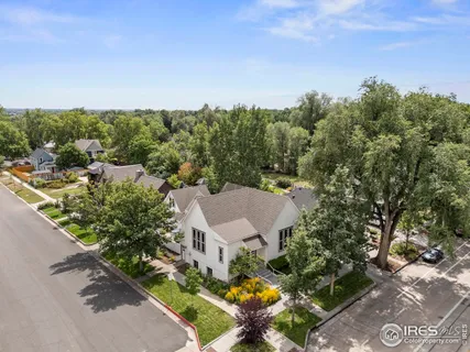an aerial view of a house with a yard and mountain view in back