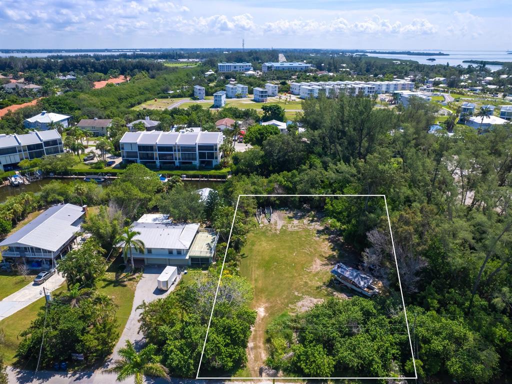 an aerial view of residential houses with outdoor space and lake view