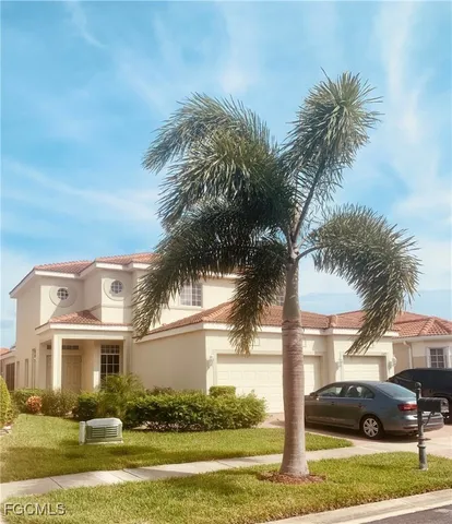 a front view of a house with a garden and palm tree