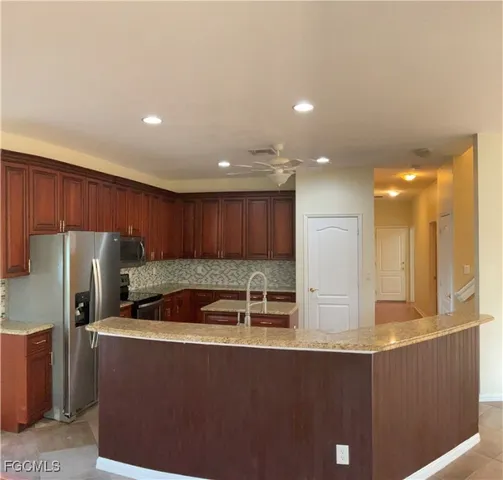 a kitchen with stainless steel appliances granite countertop a refrigerator a sink and a stove