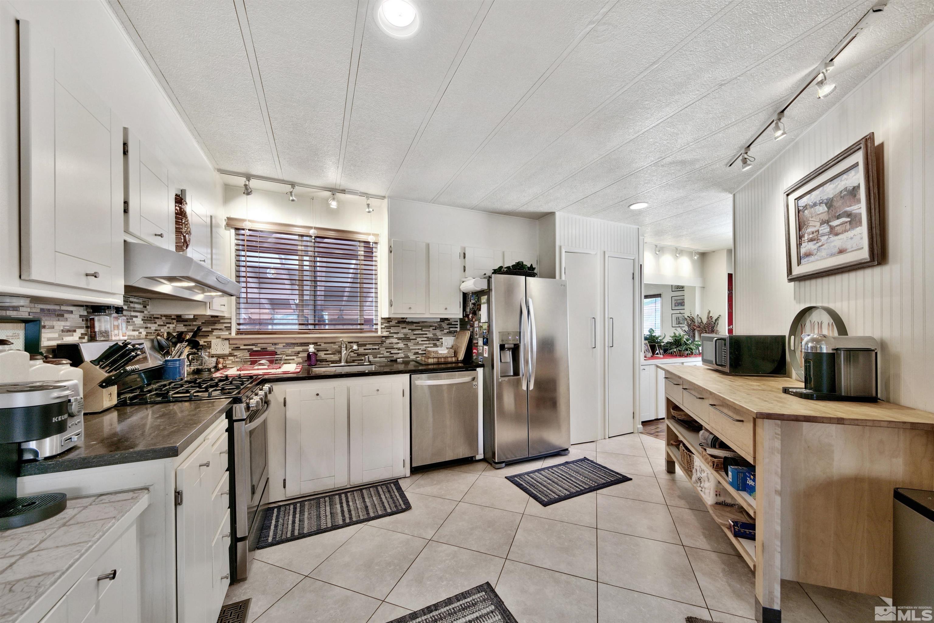 166 Crescent Drive Stateline, NV 89449 - Photo 3 of 19 a kitchen with stainless steel appliances granite countertop a sink stove and refrigerator