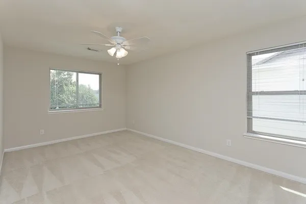 an empty room with a window and a fan