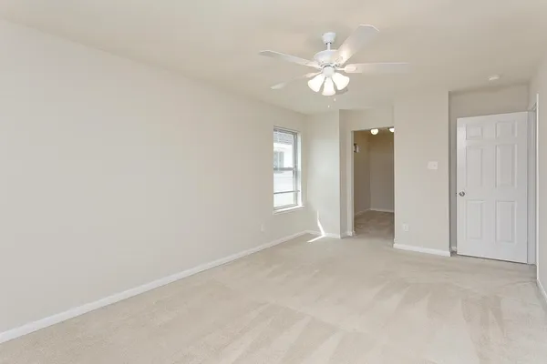 a view of an empty room with a chandelier fan