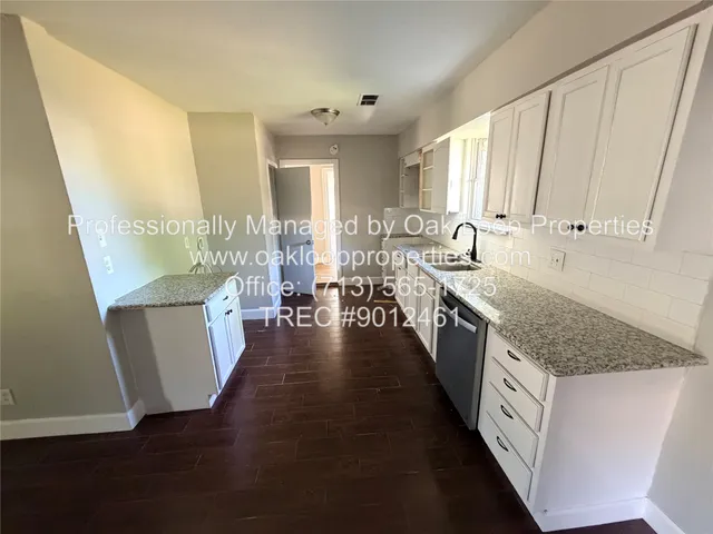 a large kitchen with stainless steel appliances granite countertop a lot of counter space and wooden floors