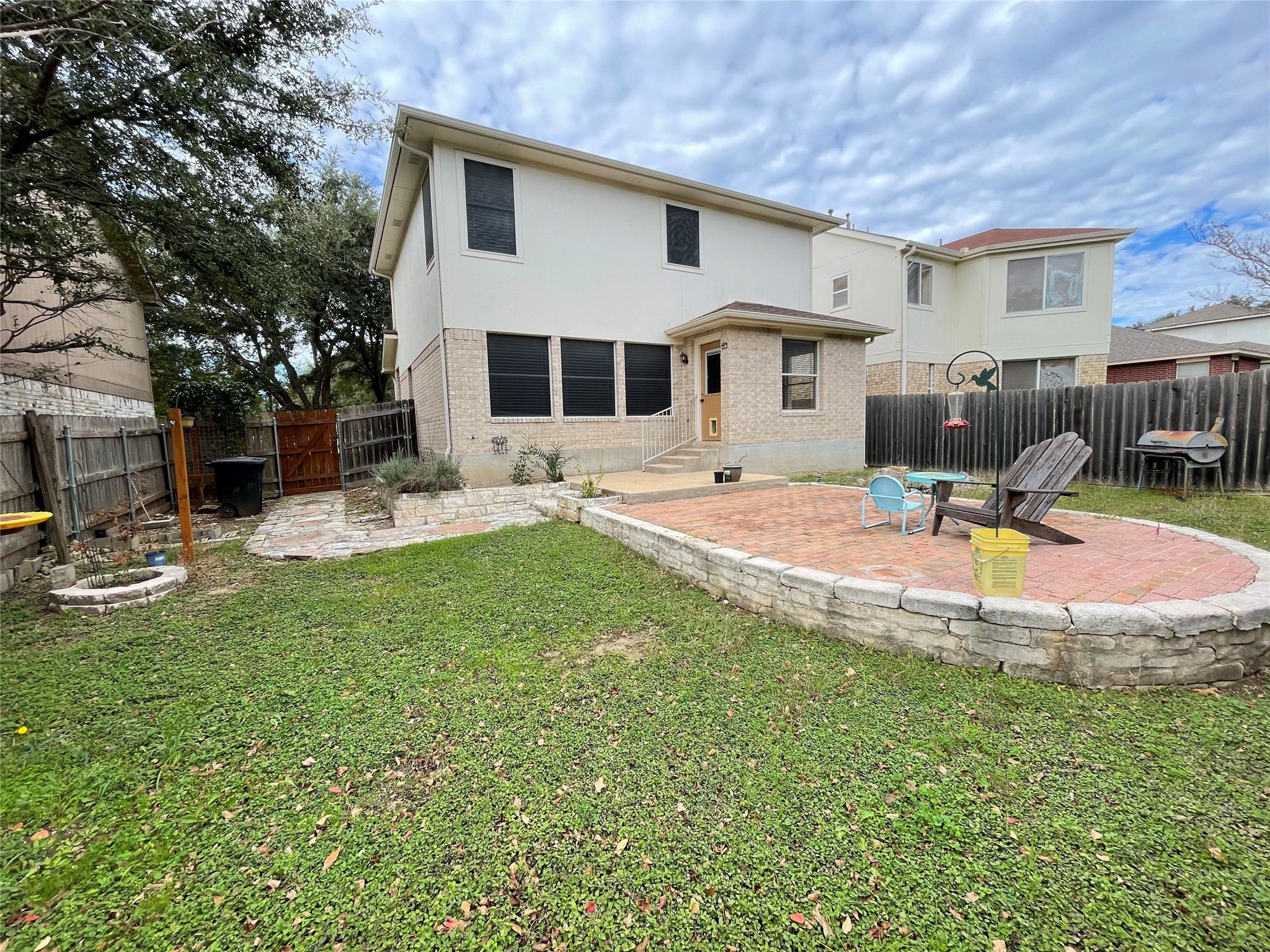 3638 Windhill Loop Round Rock, TX 78681 - Photo 31 of 32 Expansive backyard featuring a brick paver patio with a stone retaining wall, a multi-level layout, and a privacy fence
