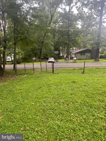 a view of pool with a bench and trees
