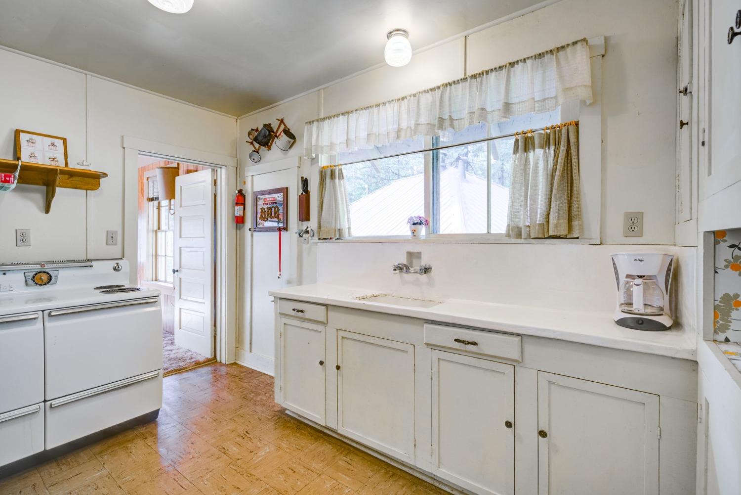 50062 Poplar Road Oakhurst, CA 93644 - Photo 20 of 38 a kitchen with cabinets and window