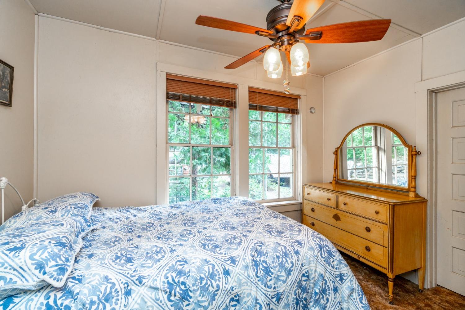 50062 Poplar Road Oakhurst, CA 93644 - Photo 21 of 38 a bedroom with a bed a chandelier and a dresser
