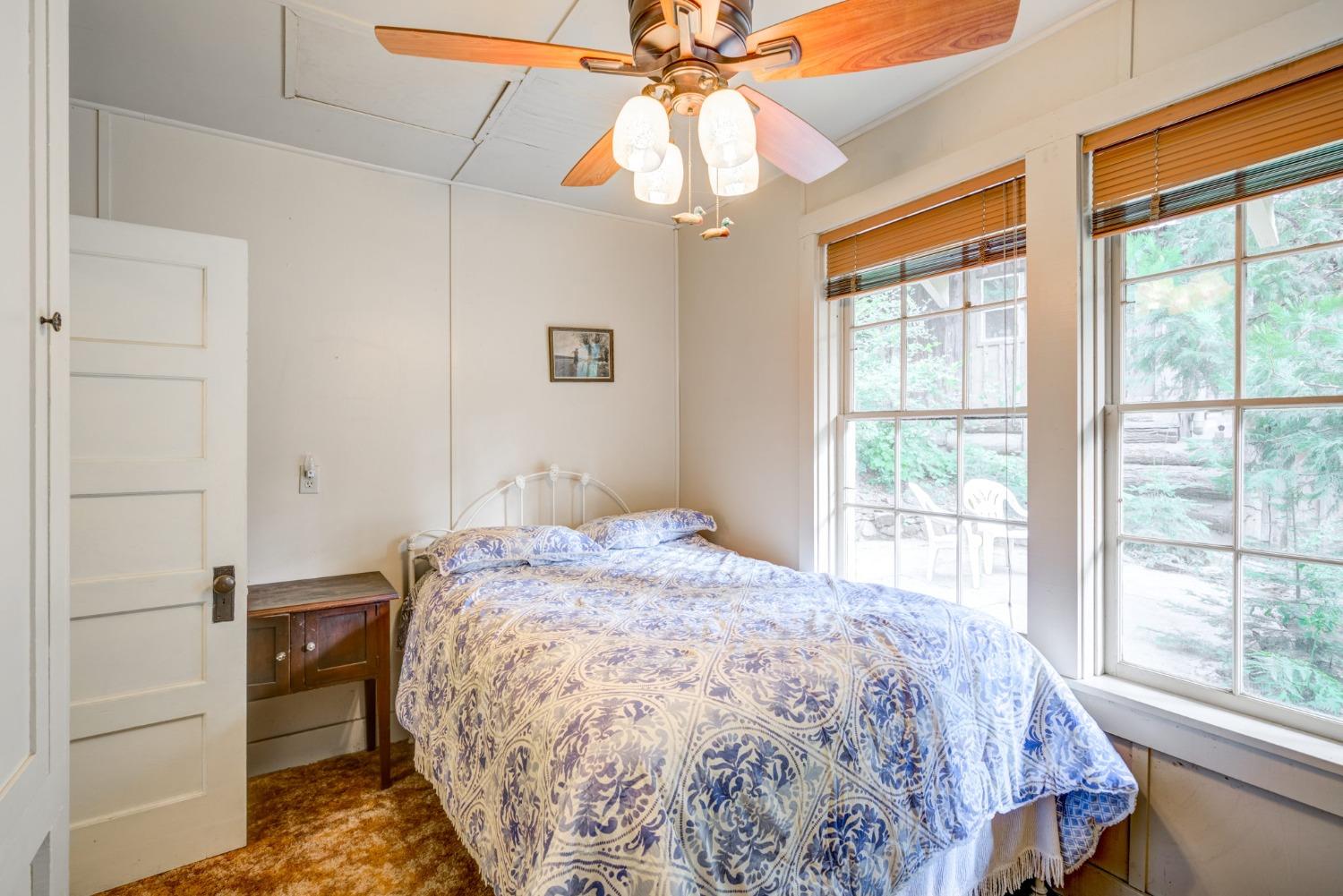 50062 Poplar Road Oakhurst, CA 93644 - Photo 22 of 38 a bedroom with a bed and a chandelier