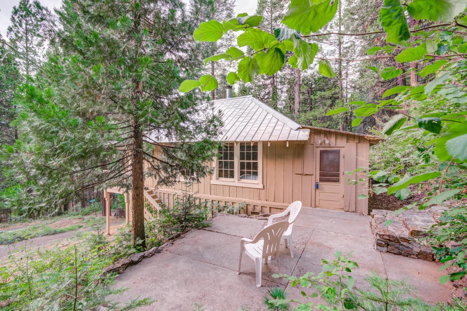 50062 Poplar Road Oakhurst, CA 93644 - Photo 29 of 38 a backyard of a house with table and chairs under an umbrella