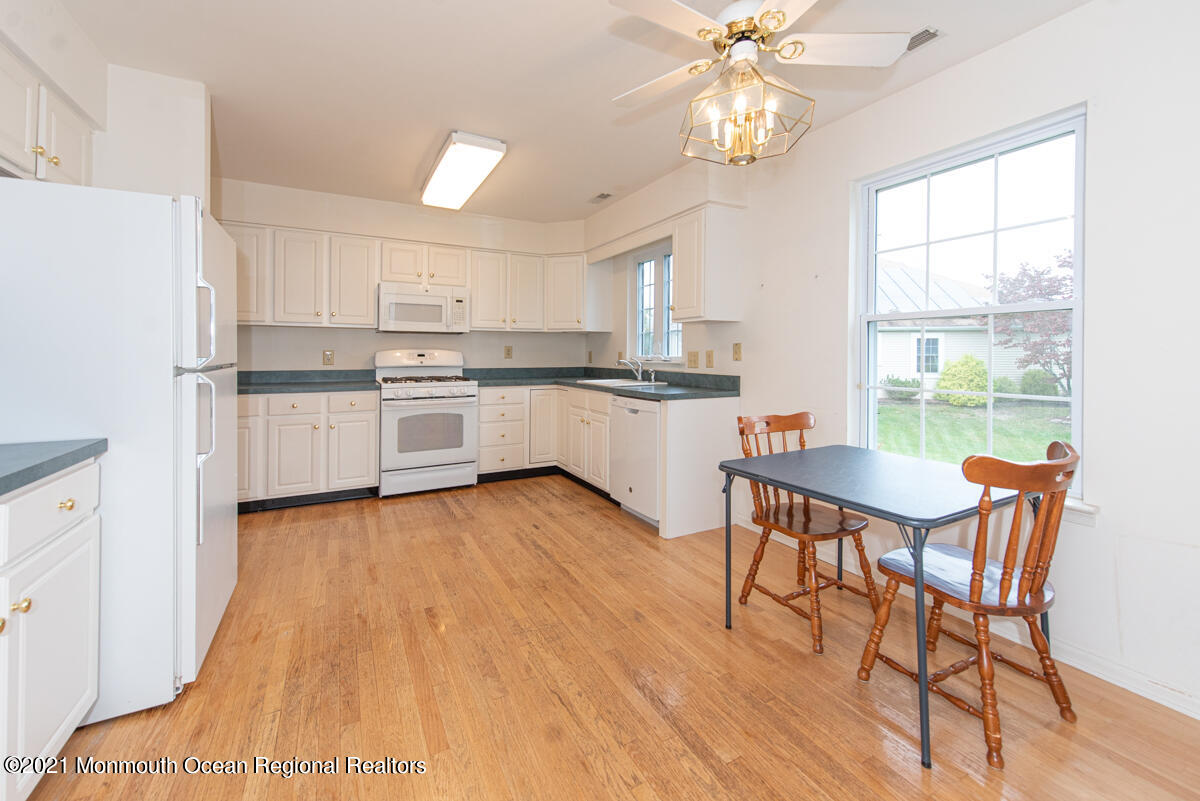 5 Dexter Lane Jackson, NJ 08527 - Photo 11 of 55 a kitchen with stainless steel appliances granite countertop a stove top oven a sink dishwasher and white cabinets with wooden floor