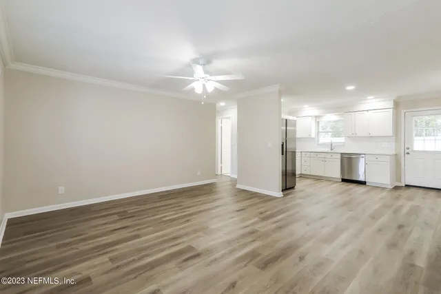 wooden floor in an empty room with a kitchen