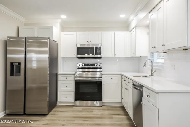 a kitchen with a sink stainless steel appliances and cabinets