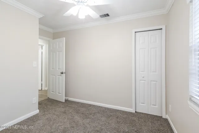an empty room with windows and closet