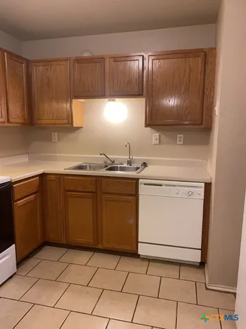 a kitchen with a sink stove and cabinets