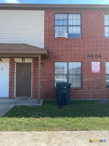 a view of a brick house with a yard