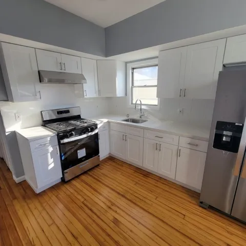 a kitchen with granite countertop a sink a stove and refrigerator